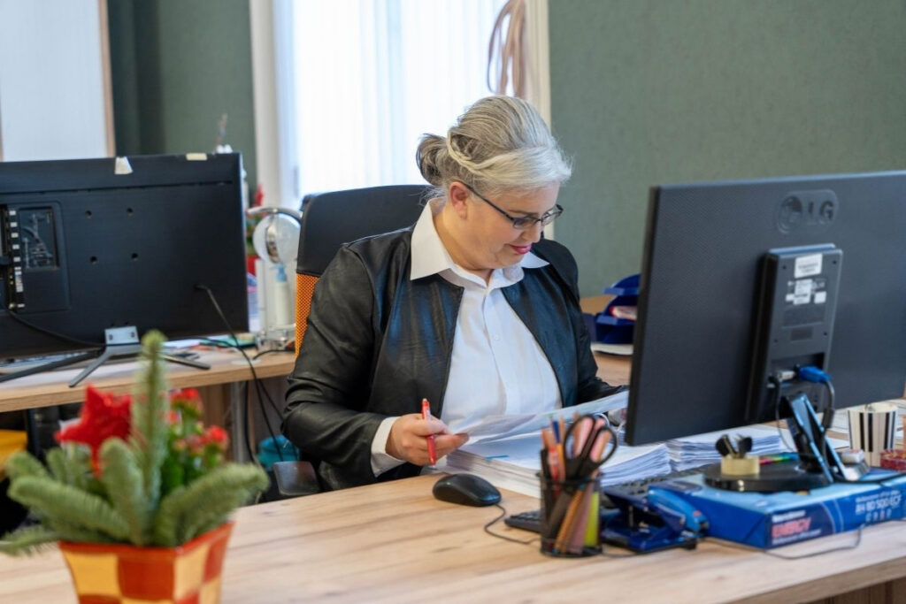 Könyvelő szakember mozgó vendéglátós vállalkozás iratait ellenőrzi az irodában.