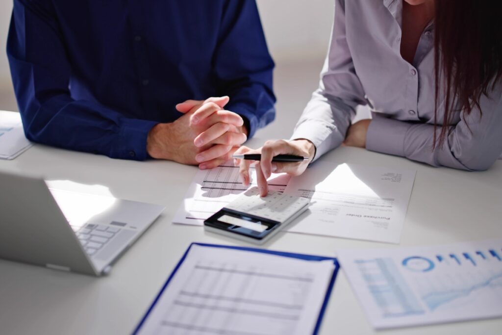 Könyvelő és ügyfél közösen elemzik a pénzügyi adatokat egy irodában